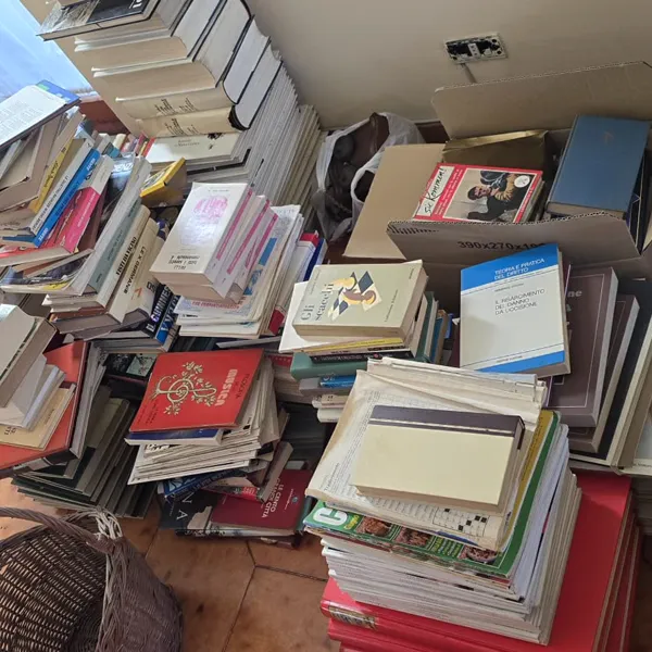Cataste di libri vecchi pronti per sgombero in stanza