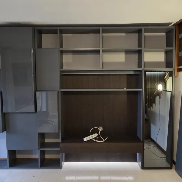 Libreria su misura grigia con specchio sotto scala montata