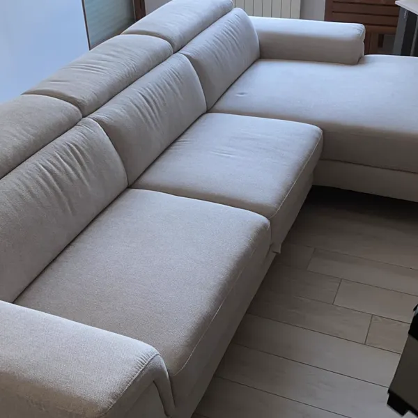 Divano con penisola beige montato in soggiorno luminoso