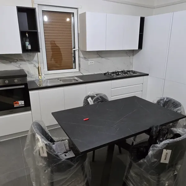 Cucina ad angolo bianca completata con elettrodomestici