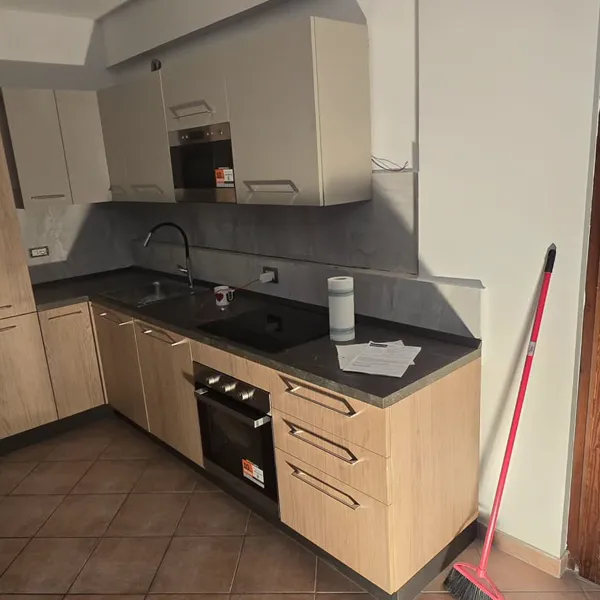 Cucina ad angolo rovere chiaro e bianco con forno e piano induzione