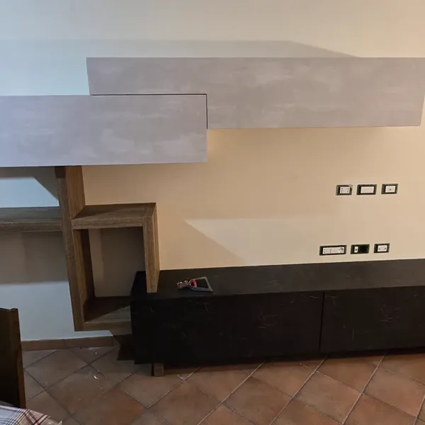 Composizione soggiorno con mensole legno e base nera marmo